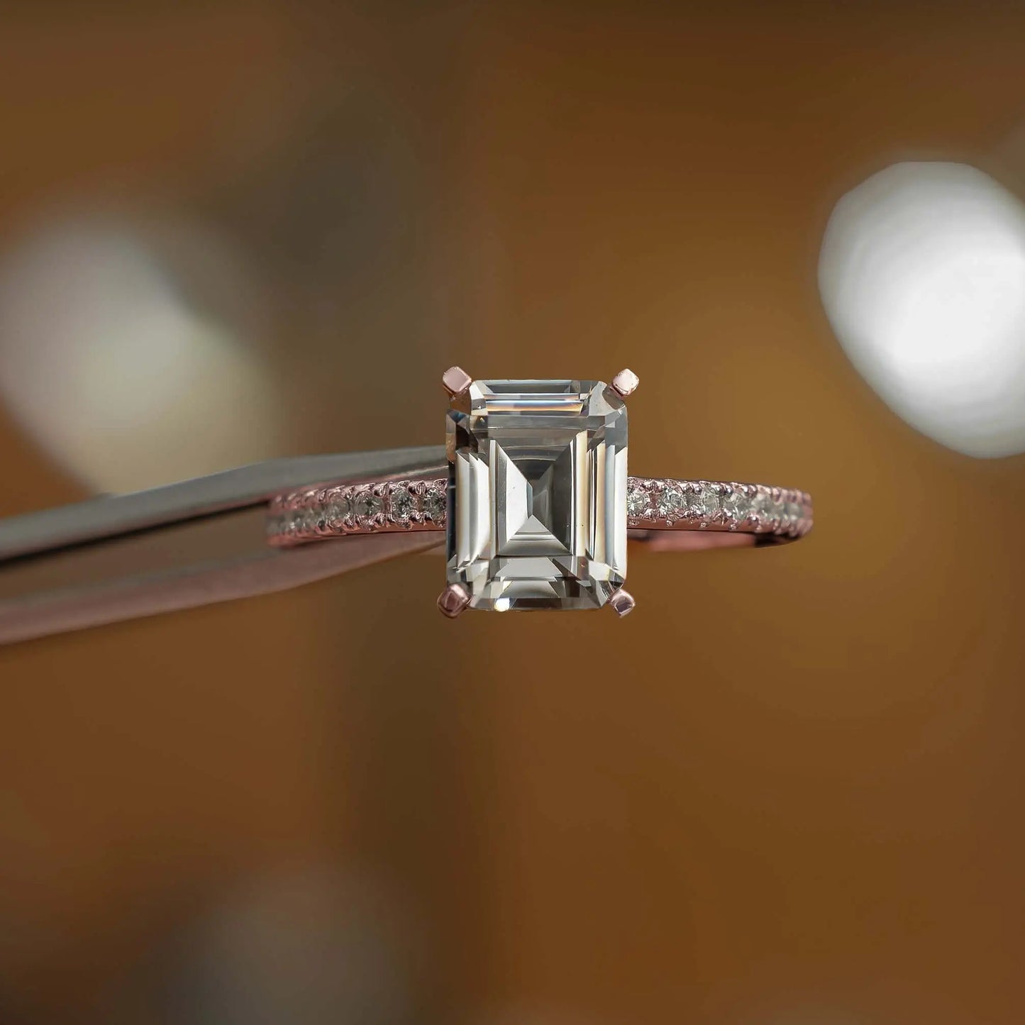 frontal view in studio of luxury emerald rose gold diamond set shoulders lab grown diamond engagement ring