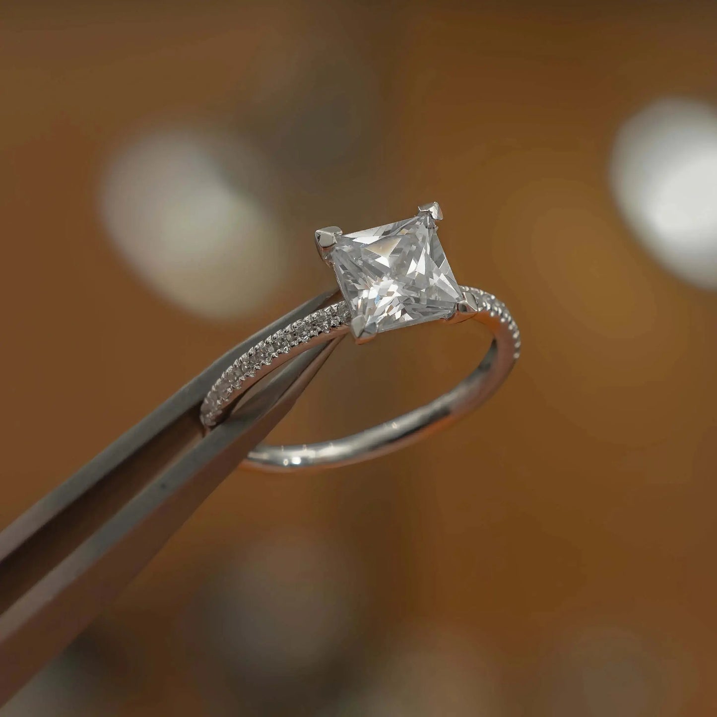 studio shot of luxury princess white gold diamond set shoulders lab grown diamond engagement ring