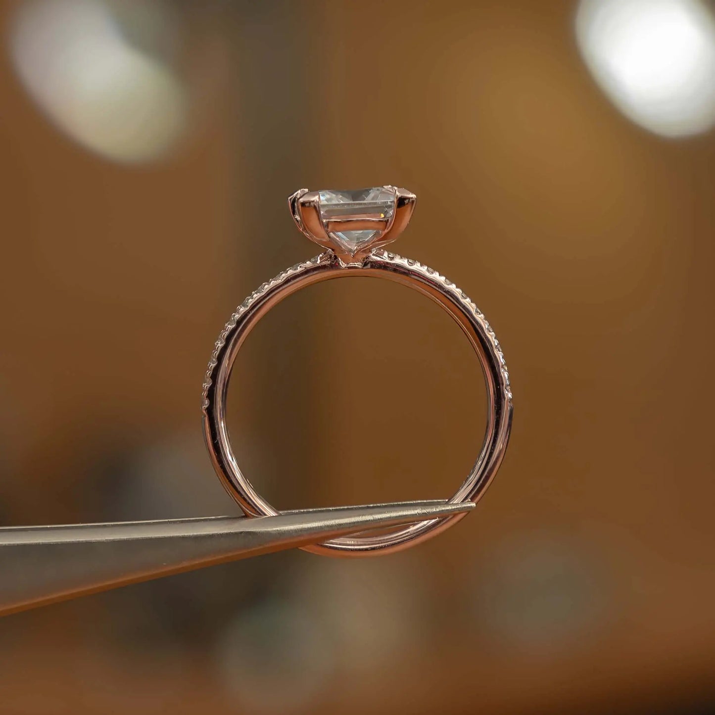 studio image holding princess rose gold diamond set shoulders lab grown diamond engagement ring