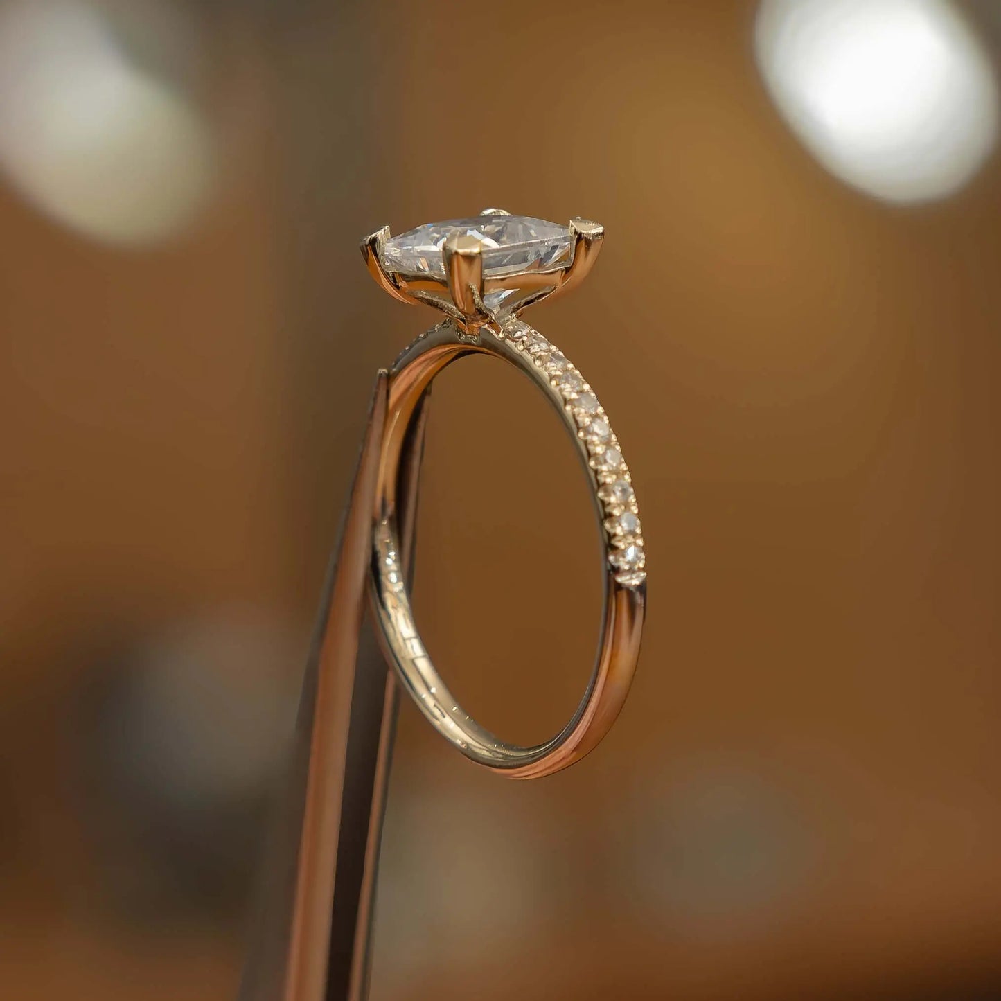 studio image of luxury princess yellow gold diamond set shoulders lab grown diamond engagement ring