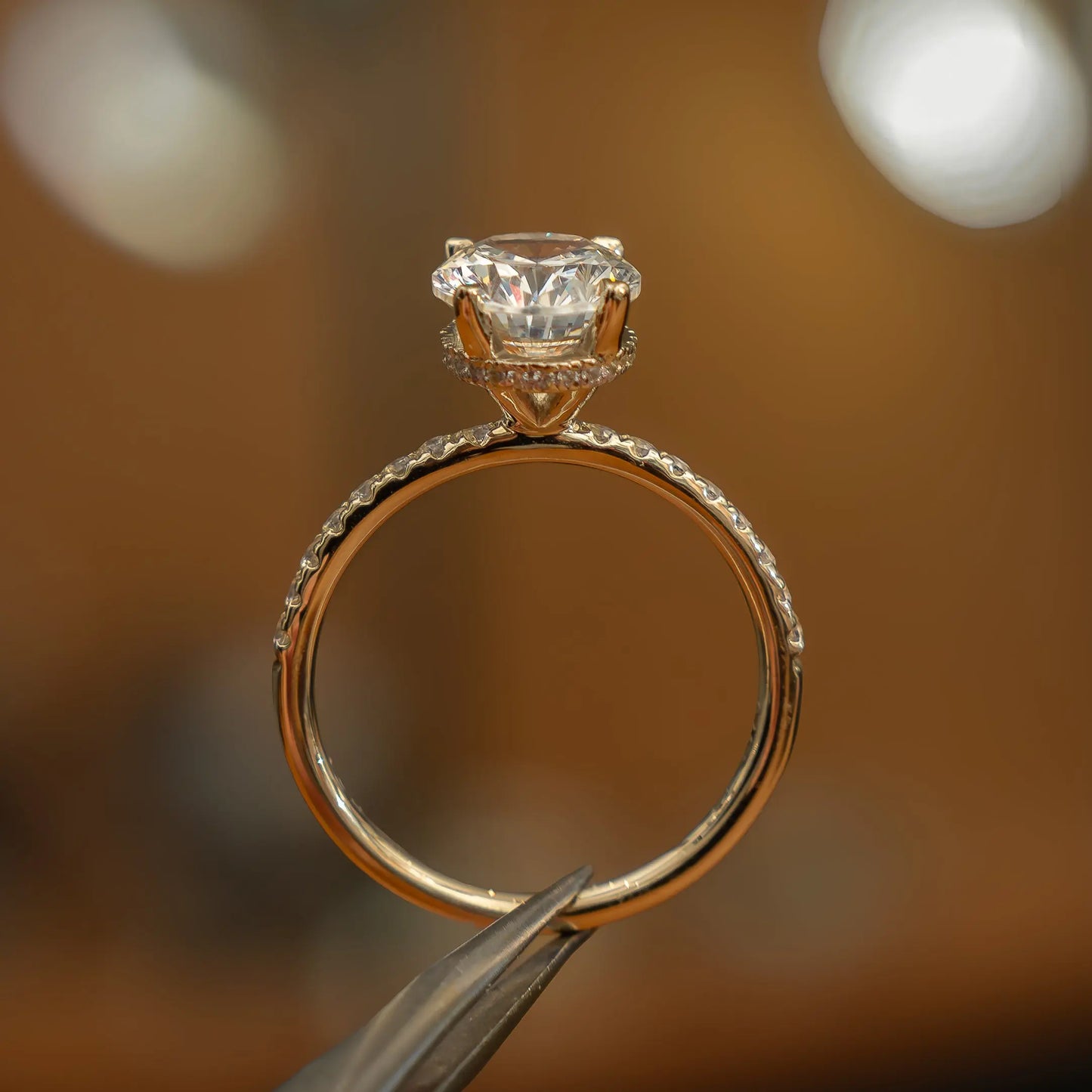 side image in studio of luxury oval yellow gold diamond set shoulders hidden halo lab grown diamond engagement ring