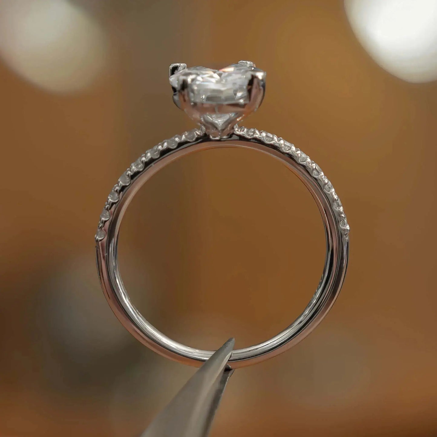 side view in studio of luxury oval platinum diamond set shoulders lab grown diamond engagement ring