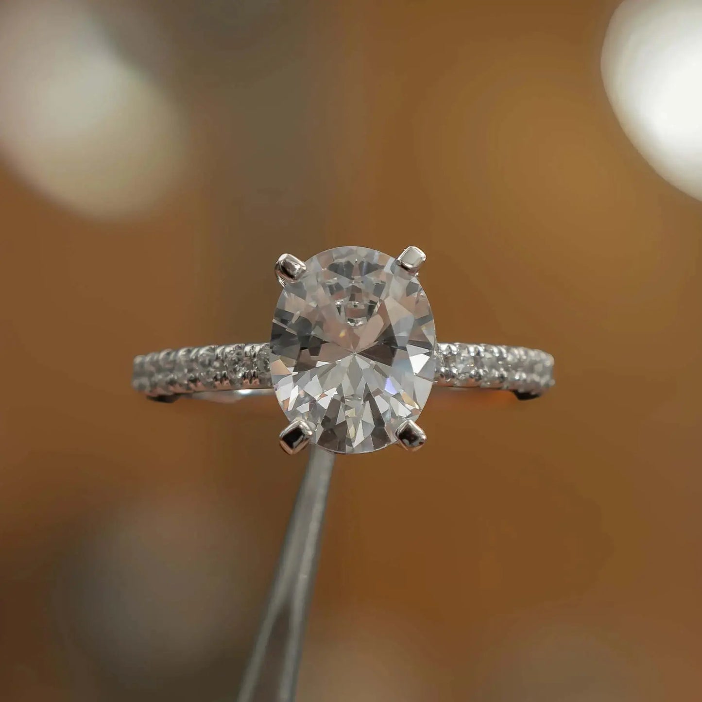 frontal view in studio of luxury oval platinum diamond set shoulders lab grown diamond engagement ring