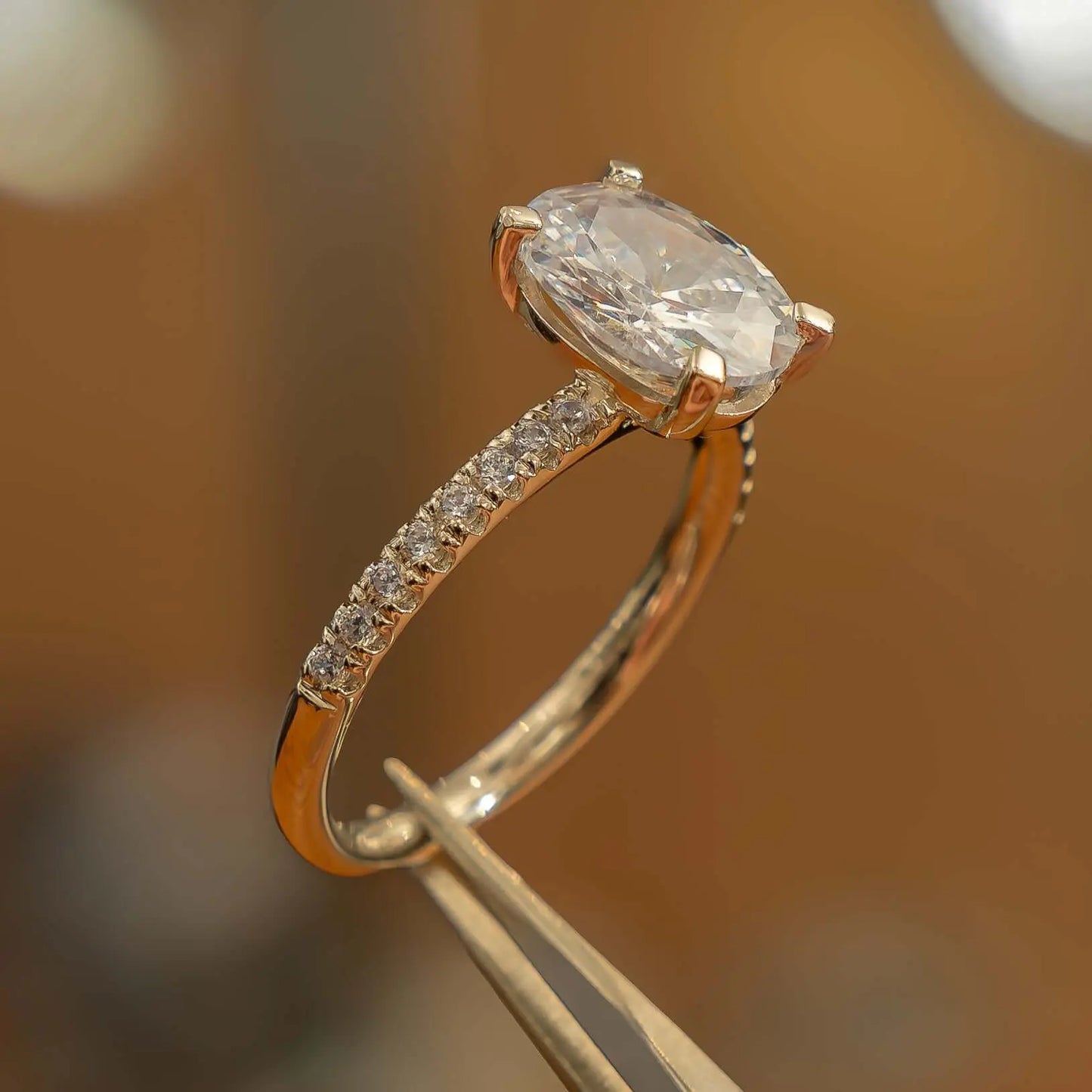 oval yellow gold diamond set shoulders lab grown diamond engagement ring side view