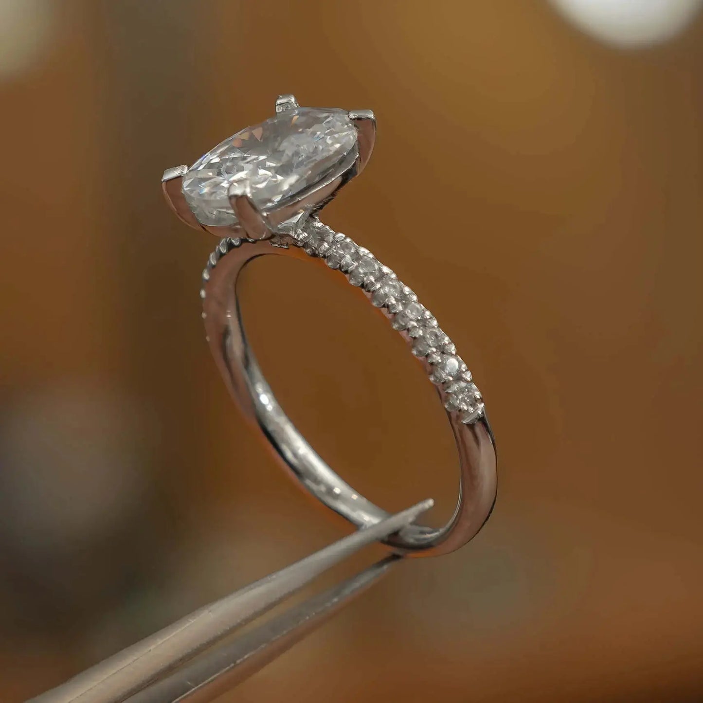 side shot in studio of luxury oval platinum diamond set shoulders lab grown diamond engagement ring