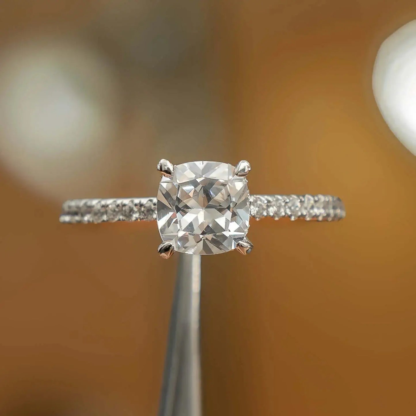 frontal view of luxury cushion platinum diamond set shoulders hidden halo lab grown diamond engagement ring
