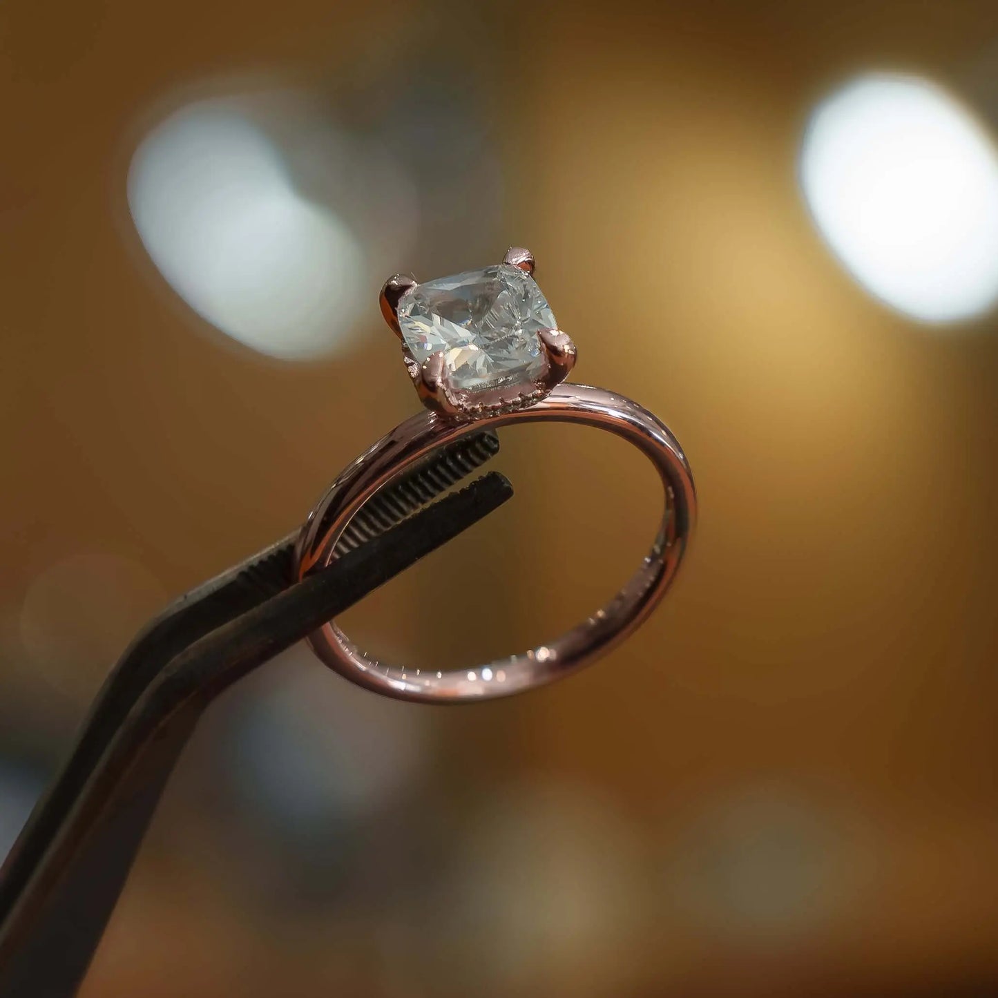 studio image of luxury cushion rose gold hidden halo solitaire lab grown diamond engagement ring