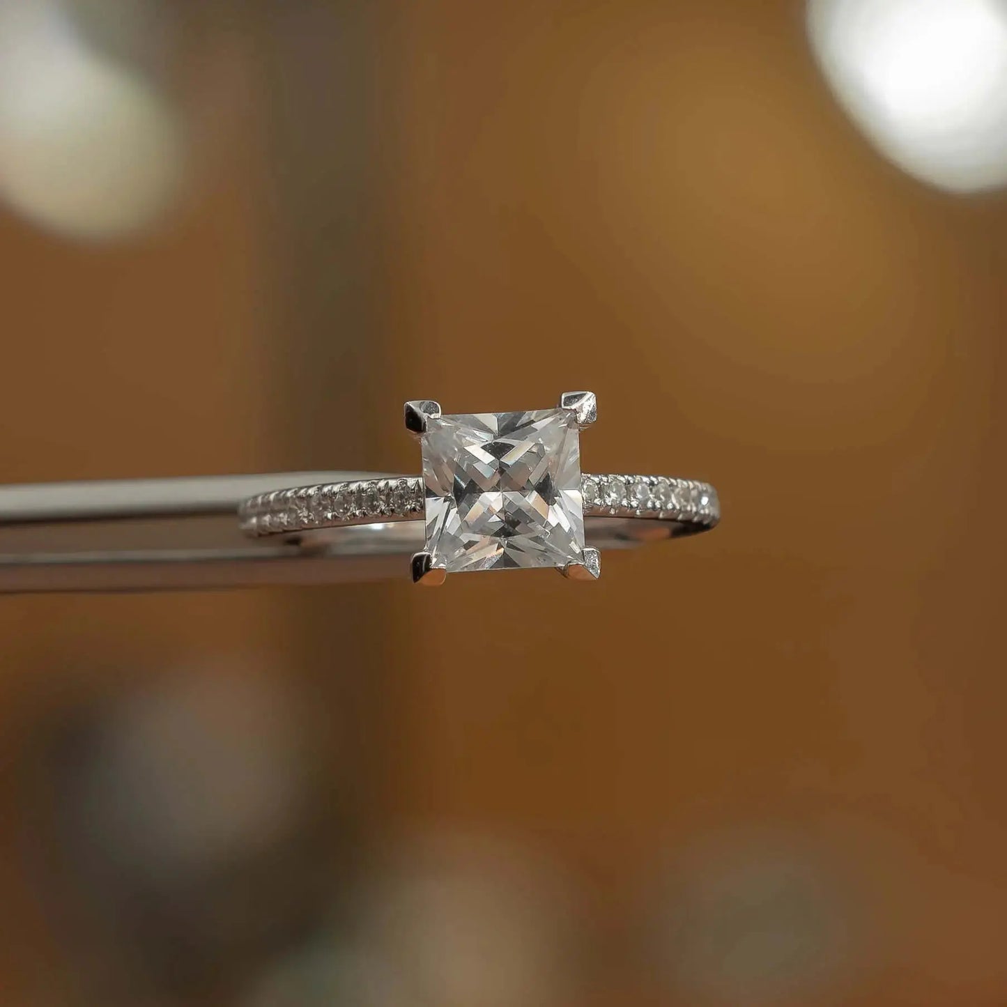 frontal view in studio of luxury princess white gold diamond set shoulders lab grown diamond engagement ring