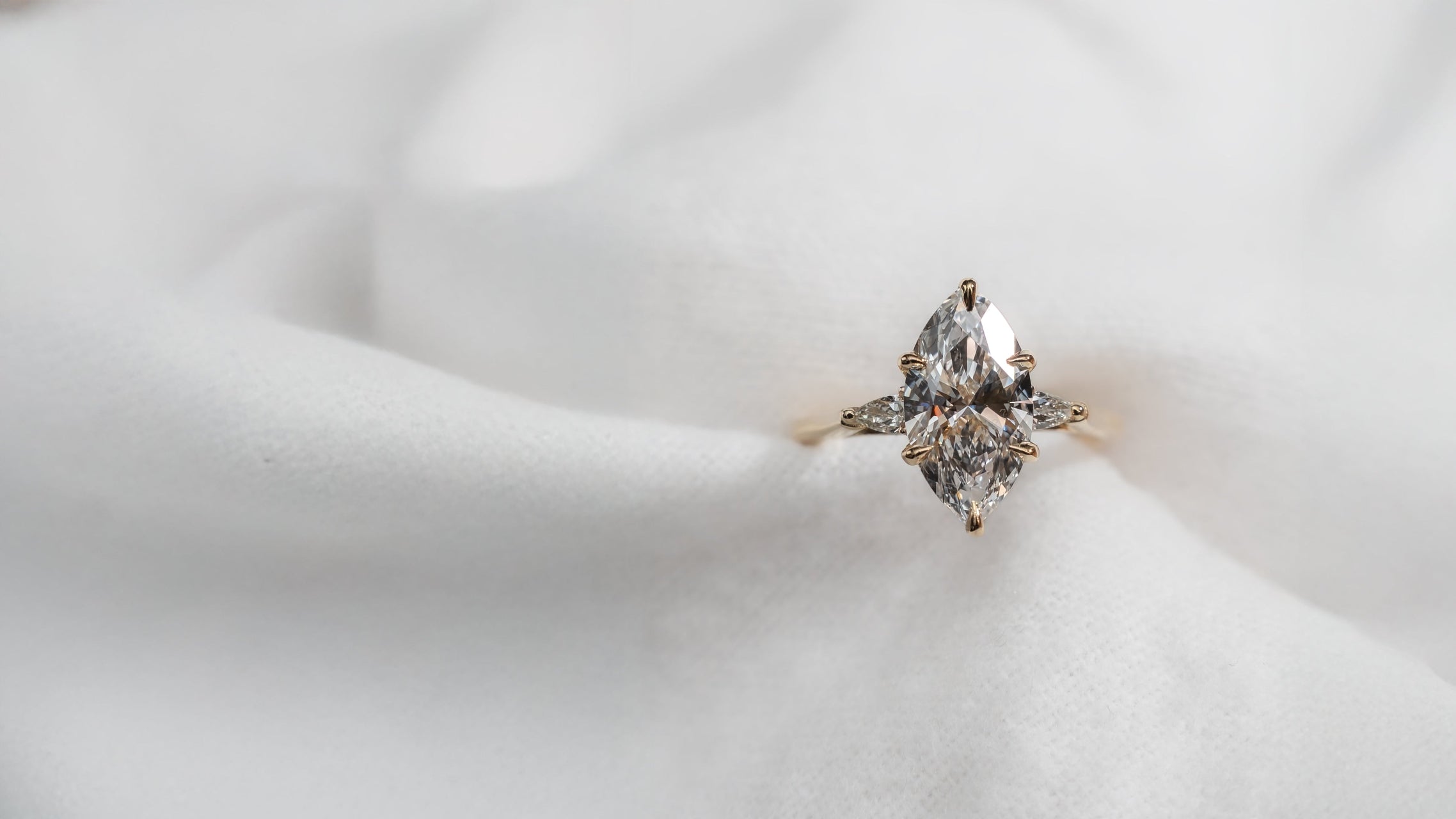 Diamond ring on a soft white fabric background