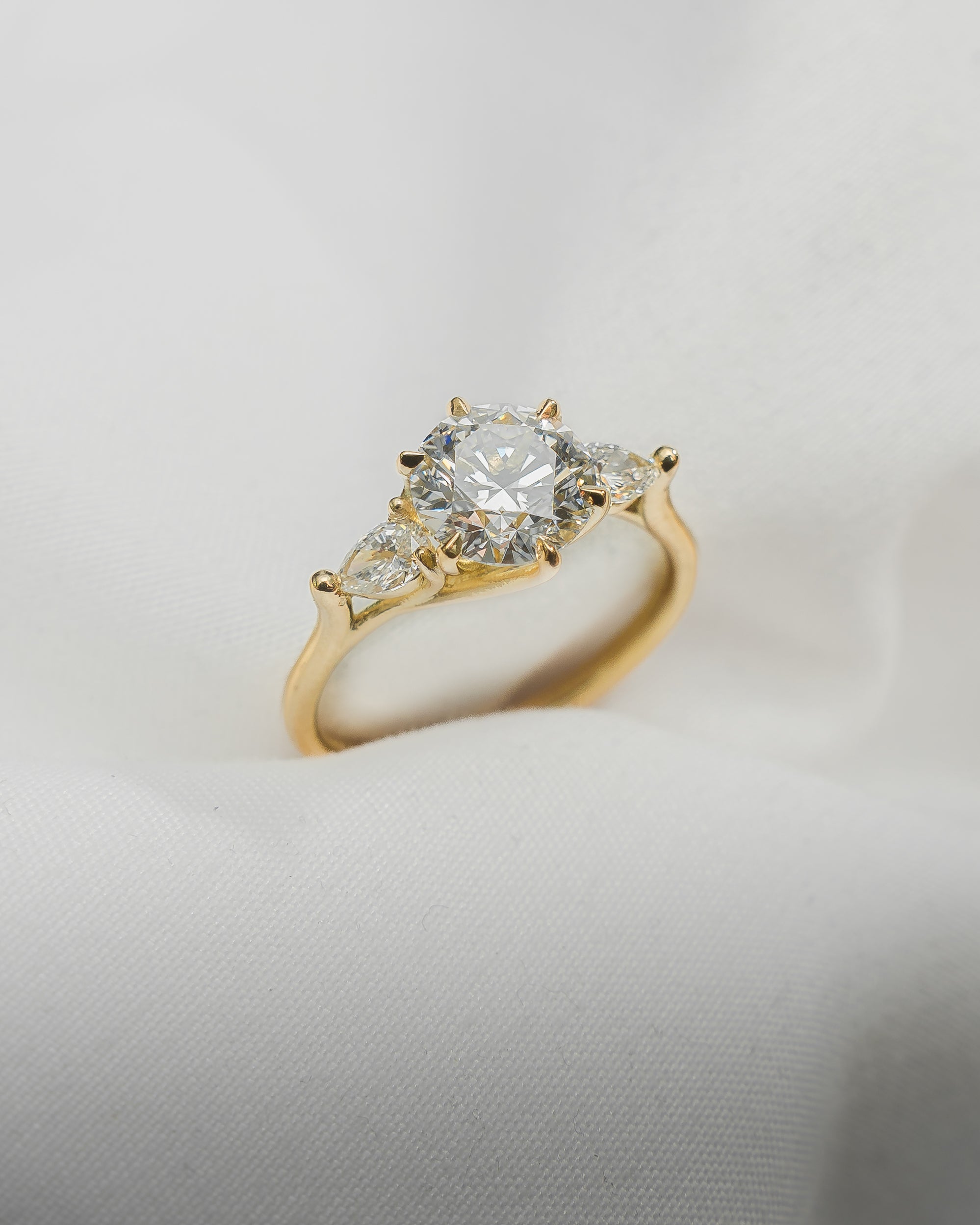 Gold ring with a diamond on a light gray background