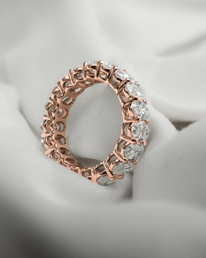Rose gold ring with diamonds on a soft fabric background