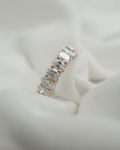 Diamond ring with rose gold setting on a light gray background