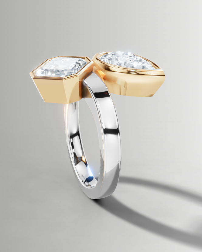 A two-tone ring featuring a silver band and geometric gold and silver settings holding clear gemstones, shown on a neutral gray background.