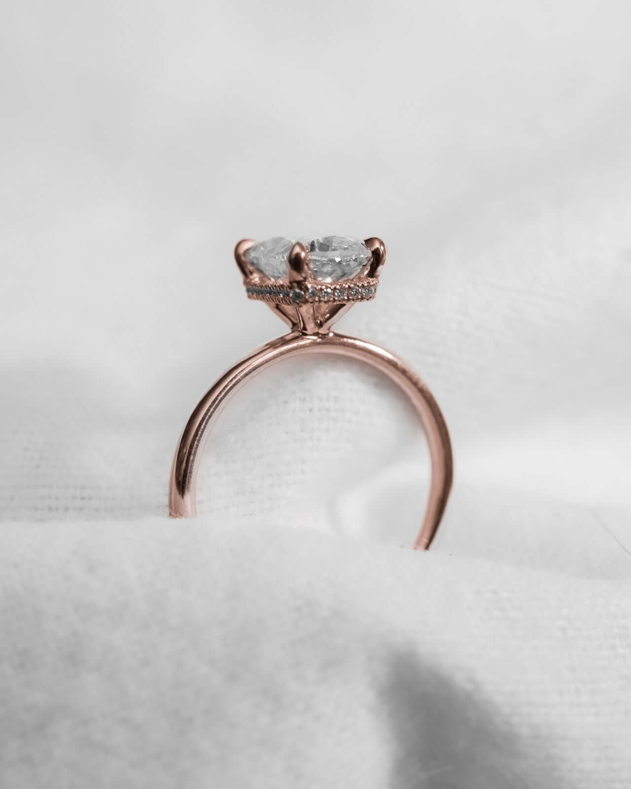 Elongated Cushion Lab Grown Diamond (Hidden Halo) | 18K Rose Gold engagement ring displayed on soft fabric.