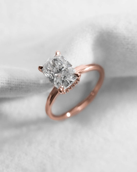 Elongated Cushion Lab Grown Diamond (Hidden Halo) | 18K Rose Gold engagement ring on fabric.