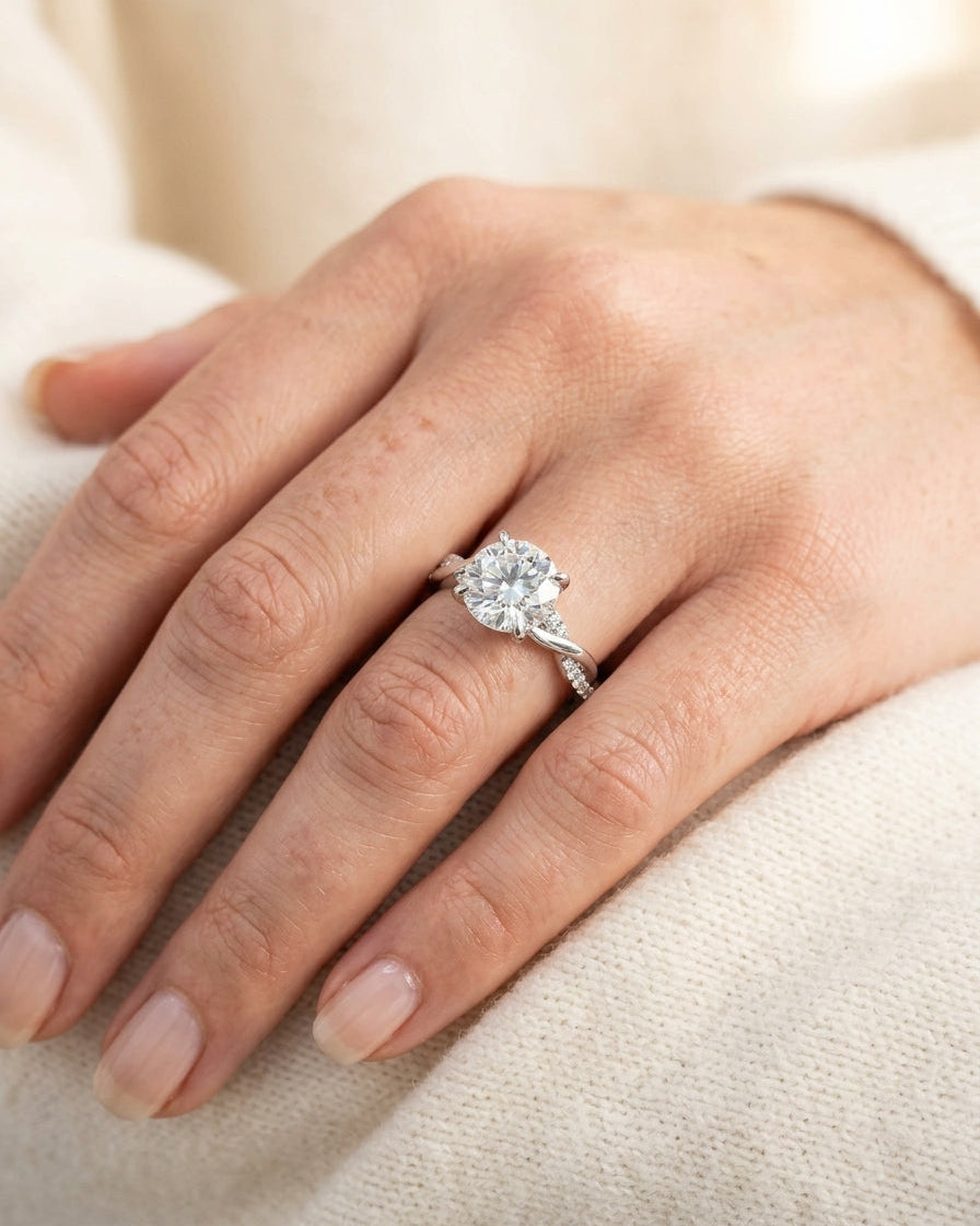 Close-up of a hand wearing a diamond ring on a light background